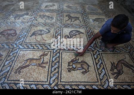 Camp Al Bureij, Gaza. 21st septembre 2022. Ahmad al-Nabahin nettoie un sol en mosaïque qu'il a découvert dans sa ferme et qui remonte à l'ère byzantine, selon les responsables, dans le camp d'Al-Bureij, dans le centre de la bande de Gaza, mercredi 21 septembre 2022. Le ministère palestinien du Tourisme et des Antiquités a annoncé la découverte de la mosaïque, qui sera protégée et un projet d'excavation commencera à Dès que possible. Photo par Ismael Mohamad/UPI crédit: UPI/Alay Live News Banque D'Images