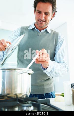 Concept de santé - homme mûr préparant des aliments diététiques. Portrait d'un homme mûr préparant des aliments dans la cuisine. Banque D'Images
