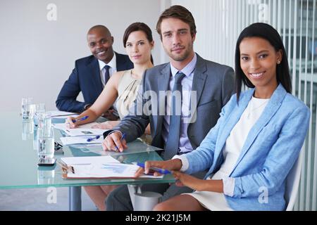 Toujours professionnel. Portrait d'un groupe d'hommes d'affaires assis à une table de conférence Banque D'Images