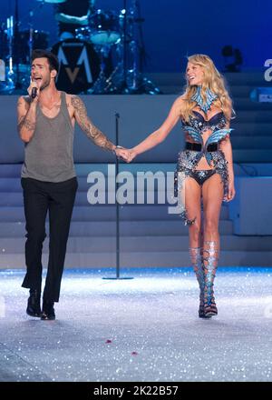 Adam Levine, de Maroon 5, tient les mains du modèle Anne V lorsqu'elle marche sur la piste lors du Secret Fashion Show 2011 de Victoria à l'avenue Lexington A. Banque D'Images