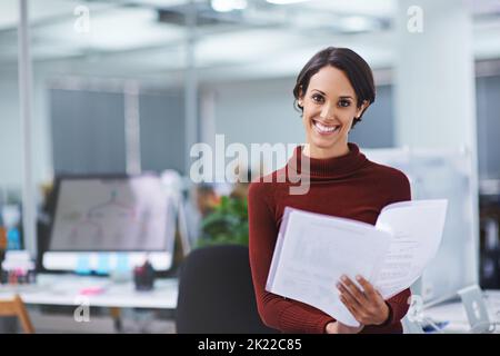 Les chiffres sont dans - et theyre a l'air super. Portrait d'une jeune femme d'affaires confiante lisant des documents administratifs dans son bureau Banque D'Images