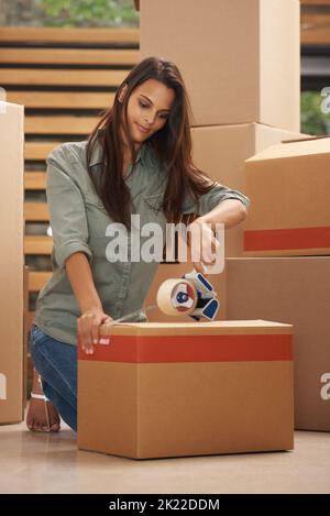 Passons à des pâturages plus verts. Une jeune femme emballant des boîtes dans un appartement. Banque D'Images