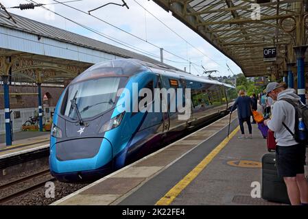 Les passagers qui attendent un train Trans Pennine Express classe 397 Nova 2 arrivent à la gare de Penrith, Cumbria, Royaume-Uni, août 2022 Banque D'Images