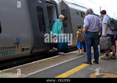 Les passagers qui montent et descendez d'un train Trans Pennine Express Class 397 Nova 2 à la gare de Penrith, Cumbria, Royaume-Uni, août 2022 Banque D'Images