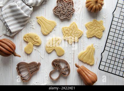 Cuisson de biscuits sous forme de citrouille et de feuilles. Pâtisserie d'automne confortable. Pâte avec emporte-pièces. Banque D'Images