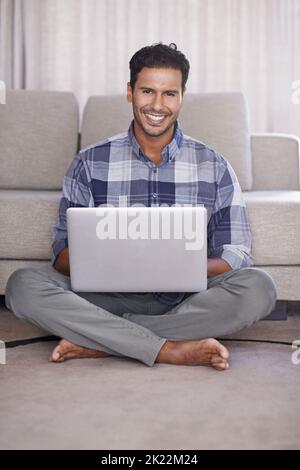 Connecté au Web. Un jeune homme utilisant son ordinateur portable à la maison Banque D'Images