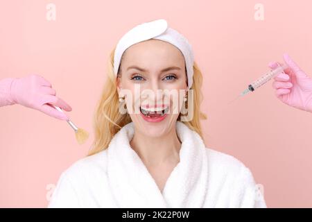 Portrait en gros plan femme les mains pensive en gants médicaux tiennent une seringue et une brosse cosmétique. Fille fait un choix de procédures faciales dans un manteau blanc sur un fond rose. Copier l'espace. Concept de choix Banque D'Images