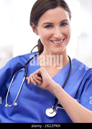 Patiemment en attente des patients. Portrait d'une jeune femme médecin dans les exfoliations Banque D'Images