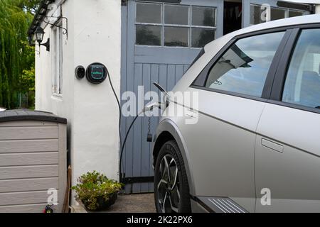 Hyundai Ioniq 5 charge à la maison, chargeur mural EV à l'extérieur d'un chargeur de boîte murale de garage rural Banque D'Images