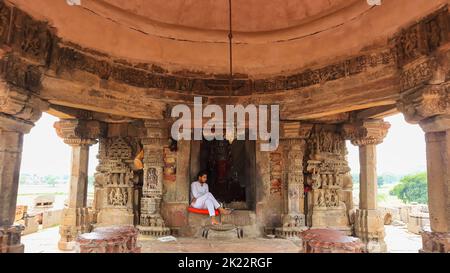 INDE, RAJASTHAN, DAUSA, juillet 2022, Priest assis à l'entrée de l'actif garbhagriha du temple, Abhaneri Banque D'Images