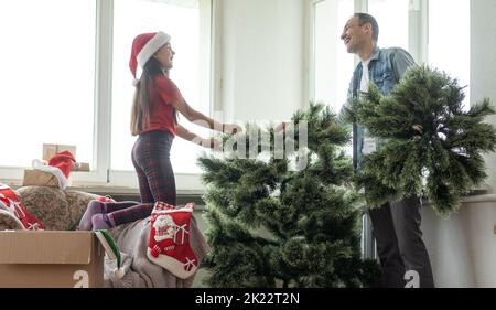 Jeune père avec un jeune fille décorant l'arbre de Noël ensemble Banque D'Images