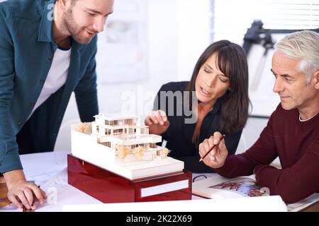 Il n'y a pas de marge d'erreur dans le jeu architectural. Trois architectes travaillant sur une nouvelle conception de bâtiment Banque D'Images