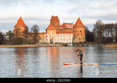 Trakai, Vilnius, Lituanie - 29 décembre 2019 : un homme sur un bateau à aubes debout sur le lac Galve, en face du château médiéval de Trakai près de Vilnius Banque D'Images