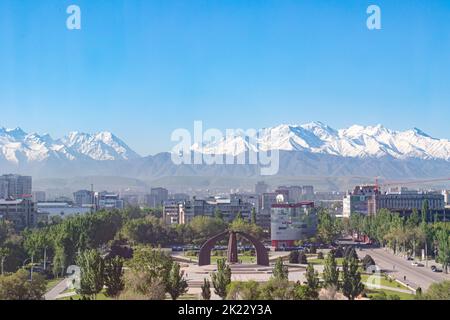 Bishkek, Kyrgyzstan - April 28, 2018: Victory square in Bishkek with on the background snow covered mountains Stock Photo