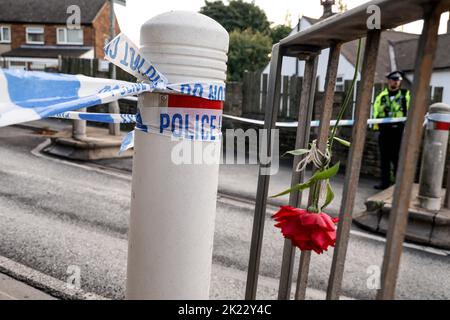 Un cordon de police et des hommages floraux près de la scène à Woodhouse Hill, à Huddersfield, où un garçon de 15 ans a été poignardé et est décédé à l'hôpital mercredi. Date de la photo: Jeudi 22 septembre 2022. Banque D'Images