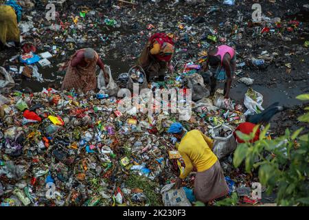 Les moyens d'existence des salariés à revenu très faible travaillant dans les zones polluées dangereuses du déversement de déchets de Chattogram dans Halishahar Chattogram. Les travailleurs collectent les matériaux recyclables de ces tas de déchets tout au long de la journée et les déposent dans des ateliers de ferraille. En tant que commerçants, ils travaillent ici toute la journée et prennent des risques sanitaires extrêmes. Chattogram, Bangladesh. Banque D'Images