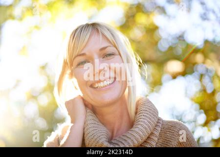 Illuminez sa beauté naturelle. Un portrait en bas angle d'une belle femme à l'extérieur dans le parc Banque D'Images