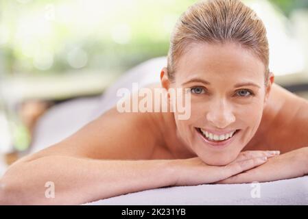 Un bonheur total. Une femme dans un spa de jour se détendant sur une table de massage Banque D'Images