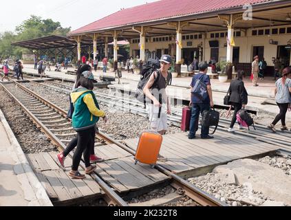 Passagers traversant les voies après leur arrivée à la gare d'Ayutthaya en Thaïlande Banque D'Images