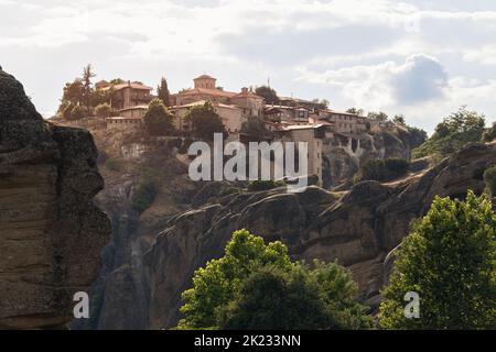Monastère Saint du Grand complexe météorologique sur le haut d'une roche abrupte baignée de lumière du soir. L'un des joyaux historiques de Meteora et le pèlerinage religieux populaire Banque D'Images