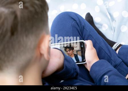 Garçon enfant 12 dos de la tête regarder vers le bas téléphone mobile regarder les médias sociaux Dhar Mann Youtube vidéo au Royaume-Uni 2022 Grande-Bretagne KATHY DEWITT Banque D'Images