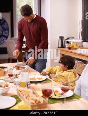 Voulez-vous un morceau de mon fameux poulet. Un père et un fils qui déjeunent en famille Banque D'Images