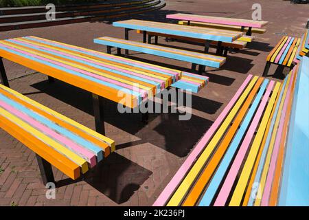 Tables et bancs extérieurs colorés sur la terrasse d'un café ou d'un restaurant de la ville en été. Mobilier d'extérieur orange, jaune, rose et bleu Banque D'Images