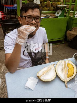 Malaisie, 10 juillet 2022 - l'homme mange des fruits duriens odorants. Banque D'Images