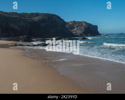 Vue sur les rochers et la falaise à Praia das Furnas plage de sable doré avec eaux turquoise de l'océan Atlantique près de Vila Nova de Milfontes, Côte de Vicentine Banque D'Images