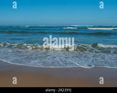 Vue panoramique bleu turquoise brisant les vagues de mer avec de la mousse blanche approchant la plage de sable doré sur la côte sauvage de Rota Vicentina au Portugal. Atlantique Banque D'Images