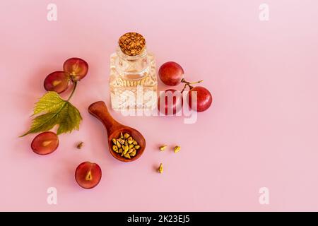 huile de pépins de raisin biologique dans une bouteille en verre de verre gaufré léger avec liège. fond rose. le concept de soins naturels, hydratant, massage Banque D'Images