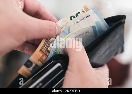 vue rapprochée des mains qui prennent de l'argent dans un portefeuille et qui dépensent de l'argent Banque D'Images