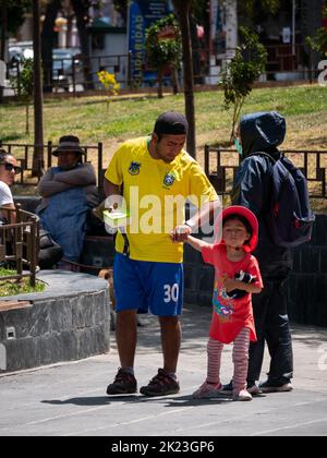 La Paz, Bolivia - September 11 2022: Bolivian Father Tries to Carry his Little Daughter by the Arm in Miraflores Plaza Stock Photo