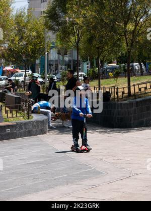 La Paz, Bolivia - September 11 2022: Little Boy Riding a Scooter in the Main Square Stock Photo