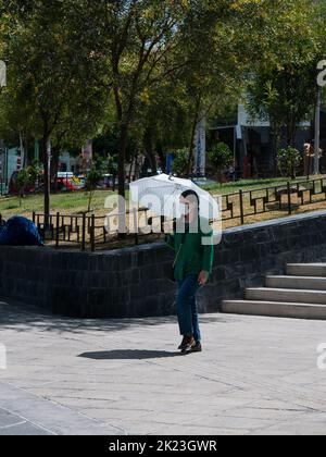 La Paz, Bolivie - 11 septembre 2022 : une jeune femme bolivienne marchant sur la place principale des Miraflores tenant un parapluie au Soleil Banque D'Images