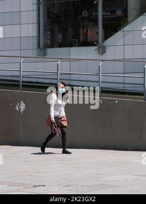 La Paz, Bolivie - 11 septembre 2022 : une jeune femme bolivienne utilisant un masque bleu marche sur la place principale de Miraflores Banque D'Images