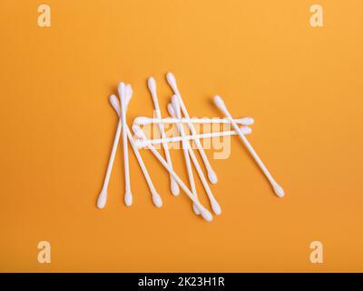 White cotton swabs on an orange background. Stock Photo