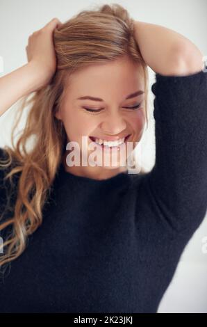 Adoptez des cheveux salissants. Portrait d'une belle jeune femme avec ses mains sur la tête Banque D'Images