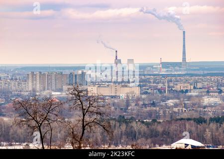 Vue panoramique sur la rive gauche de Kiev depuis le parc de la gloire éternelle. Des arbres, des bâtiments et des usines avec des cheminées à forte fumée apparaissent dans le banc Banque D'Images