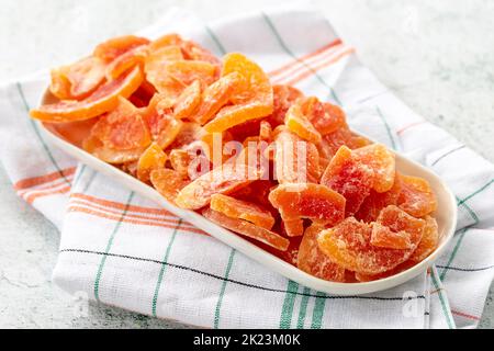 Tranche de papaye séchée sur fond gris. Fruits séchés à la lumière du soleil. Gros plan Banque D'Images