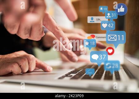 Saisie au doigt sur le clavier de l'ordinateur portable avec de nombreuses icônes d'actualité comme concept de médias sociaux Banque D'Images