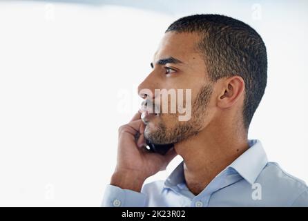 Obtenir cet appel important. Un beau jeune homme d'affaires utilisant dans le téléphone portable dans le bureau Banque D'Images