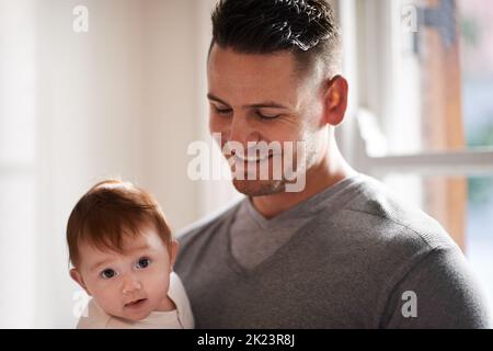 HES un père qui se déracine. Un jeune père tenant son adorable bébé fille. Banque D'Images