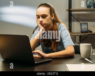 Réunion en ligne ennuyeuse. Style de vie de travail. Travailler tard. Femme d'affaires fatiguée dormant dans un bureau, lampe dans un espace de travail Banque D'Images