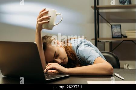 Style de vie de travail. Travailler tard. Travail à distance. Femme d'affaires fatiguée dormant dans une lampe de bureau dans un espace de travail Banque D'Images