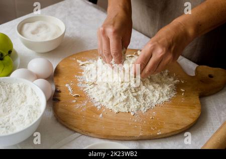 Processus de fabrication de la galette de pomme et de prune maison. Cuisine d'automne traditionnelle de saison. Femme qui fait de la pâte. Concept de cuisson. Banque D'Images