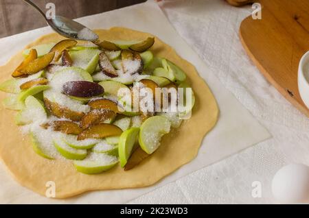 Process of making homemade apple and plum galette. Seasonal traditional autumn baking. Baking concept. Stock Photo