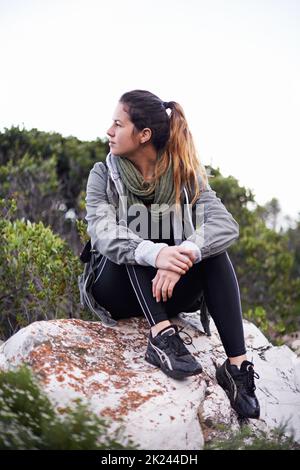 Je viens de loin... une jeune femme attirante qui fait une pause pendant qu'elle fait de la randonnée Banque D'Images