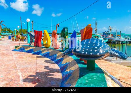 Lettres de bienvenue colorées et panneau Letras Holbox sur la belle île Holbox à côté du port de ferry et de quai avec vagues turquoise et ciel bleu dedans Banque D'Images