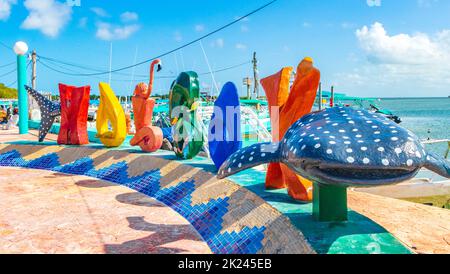 Lettres de bienvenue colorées et panneau Letras Holbox sur la belle île Holbox à côté du port de ferry et de quai avec vagues turquoise et ciel bleu dedans Banque D'Images